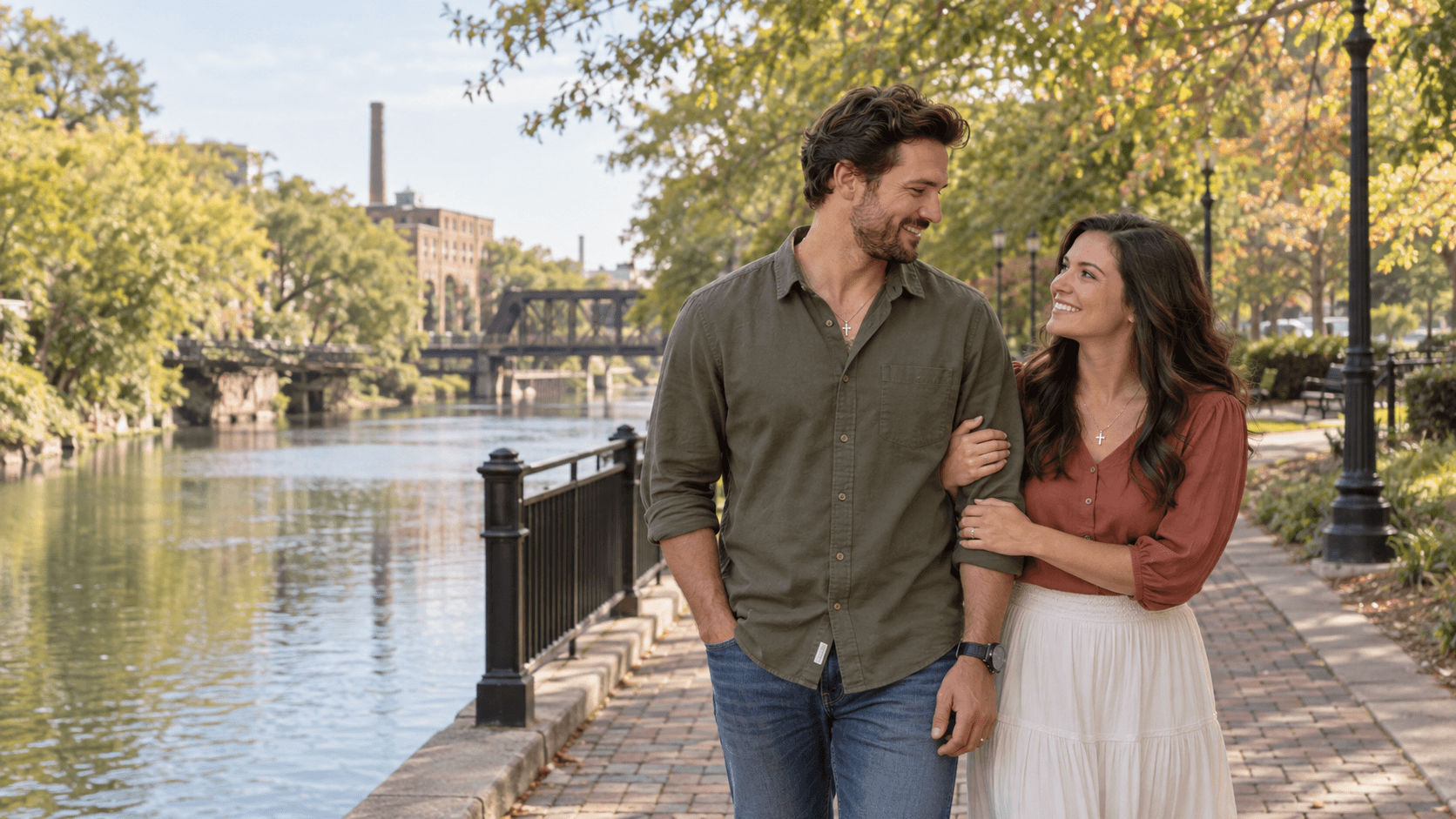 Couple with cross necklaces on a leafy canal-side path inspired by Columbia Riverfront Park.